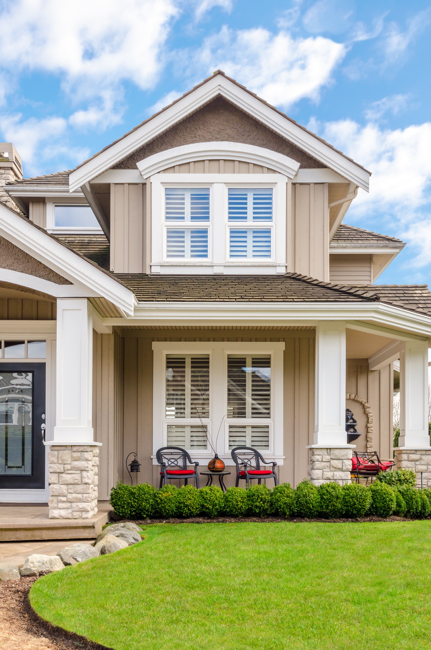 Entrance of a luxury house with a patio on a bright, sunny day. Home exterior.